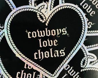 May include: A black and white heart-shaped sticker with a rope border. The sticker says "cowboys love cholas" in a gothic font.