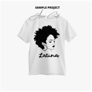 May include: A white t-shirt with a black silhouette of a woman with an afro hairstyle and the word "Latina" printed below. The design is simple and stylish.