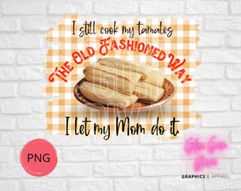 Op de afbeelding: Digitale afbeelding met tamales op een bord en de tekst: "Ik kook mijn tamales nog steeds op de ouderwetse manier, ik laat mijn moeder het doen." Het ontwerp bevat een PNG-afbeelding en de woorden "Graphics & Apparel".