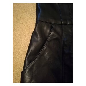 May include: Black leather skirt with two pockets on the front.