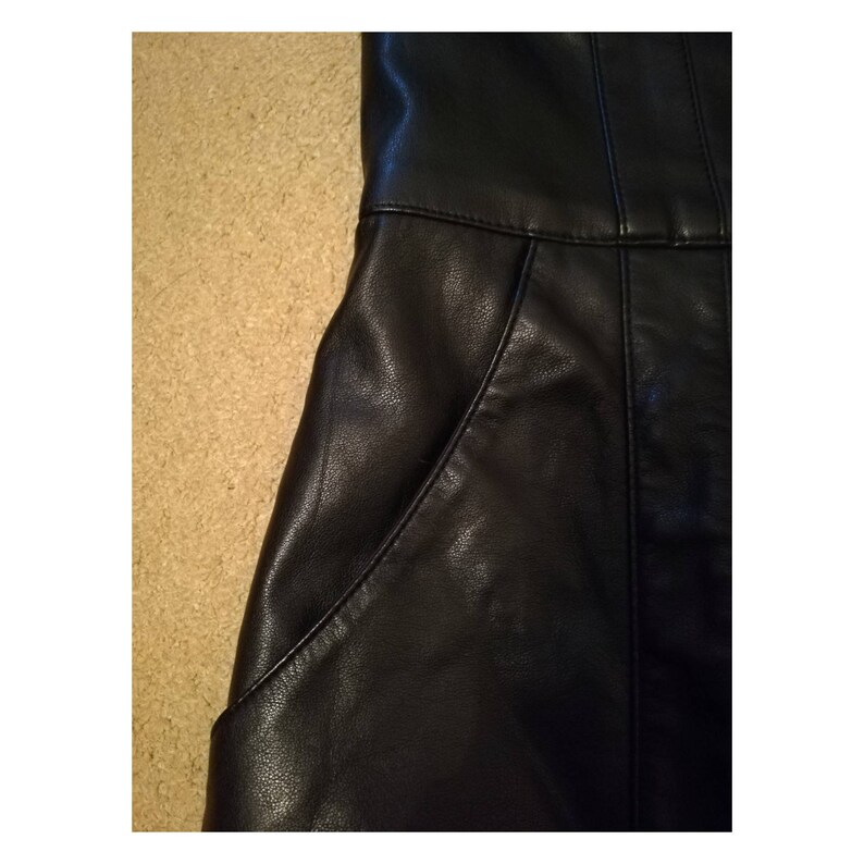 May include: Black leather skirt with two pockets on the front.