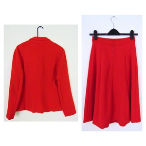 May include: A red blazer and skirt suit. The blazer has a classic cut with long sleeves and a button closure. The skirt is A-line and falls to the knee.
