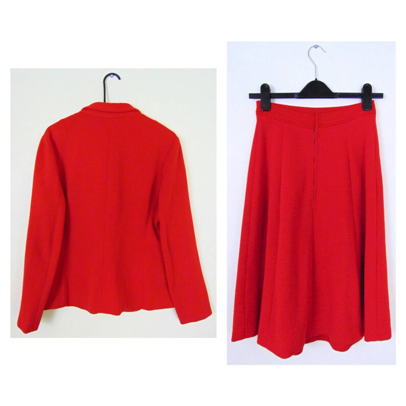 May include: A red blazer and skirt suit. The blazer has a classic cut with long sleeves and a button closure. The skirt is A-line and falls to the knee.