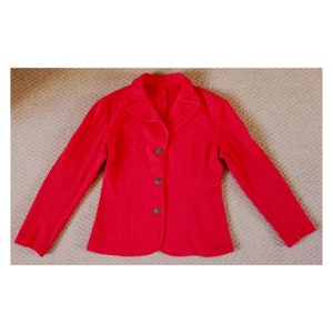 May include: A red blazer with a notched collar and four buttons down the front.