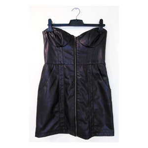 May include: A black strapless dress made of faux leather with a zipper down the front. The dress has a fitted bodice and a slightly flared skirt.