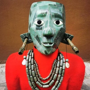 May include: A green jade mask with a red felt bust and a multi-strand necklace of green jade beads.