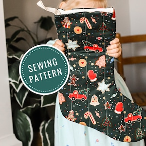 Puede incluir: Un calcetín navideño con un fondo verde oscuro y patrones festivos, que incluyen camiones rojos, hombres de jengibre y bastones de caramelo. El calcetín tiene un lazo blanco y el texto "SEWING PATTERN" en un círculo.