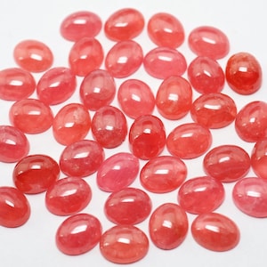 K&ouml;nnte beinhalten: Eine Sammlung von 30 ovalen, rosafarbenen, halbedlen Edelsteinen. Die Steine sind glatt und poliert und haben einen leichten Glanz.