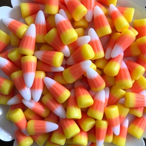 May include: A bowl filled with orange and white candy corn. The candy corn is arranged in a random pattern.