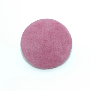 May include: A round, pink, suede button.