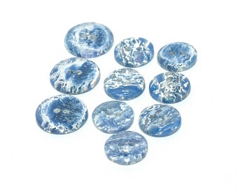 May include: Ten blue and white swirl patterned buttons. The buttons are round and have two holes.