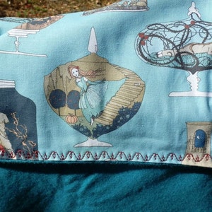 Pu&ograve; includere: Un tessuto verde acqua e azzurro con una stampa stravagante con illustrazioni di figure in vasi di vetro ed elementi decorativi. Il tessuto &egrave; bordato con una cucitura rossa decorativa ed &egrave; sovrapposto a un pile verde acqua.