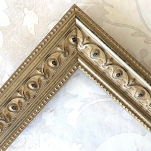 Pu&ograve; includere: Una cornice dorata con finitura anticata e dettagli decorativi. La cornice ha un bordo perlato e un design in rilievo.