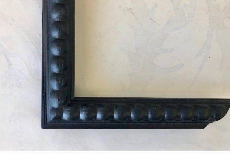 black frame with a chunky bead detail