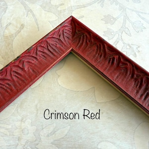 May include: Crimson red picture frame corner with carved floral design. The frame is a deep red color with a slightly distressed finish. The text "Crimson Red" is written in a script font.