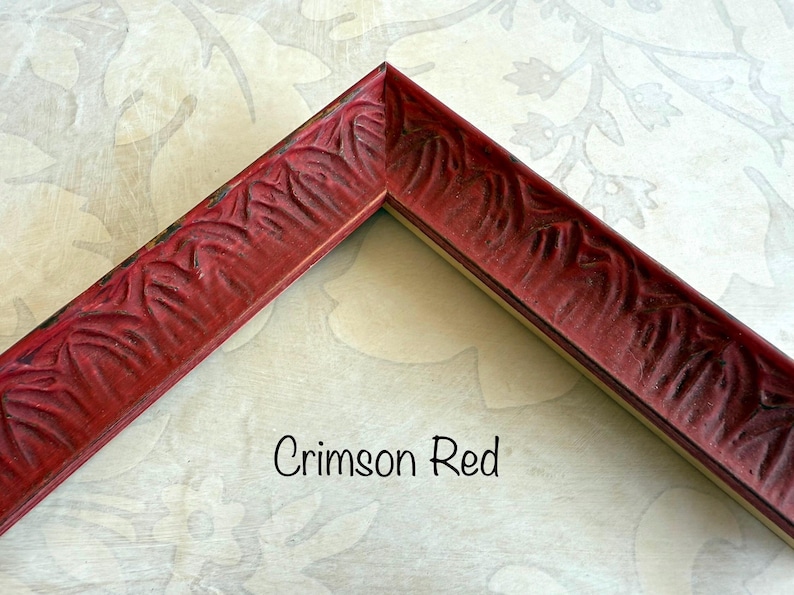 May include: Crimson red picture frame corner with carved floral design. The frame is a deep red color with a slightly distressed finish. The text "Crimson Red" is written in a script font.