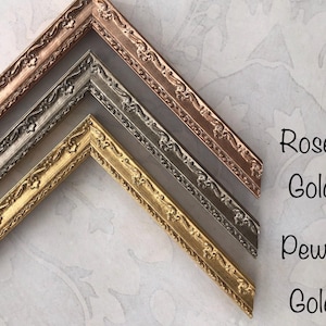May include: Close-up of decorative picture frame corners in rose gold, pewter, and gold. The frames have ornate floral detailing. Text on the right reads "Rose-Gold", "Pewter", and "Gold".