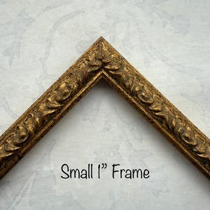 May include: A small, ornate gold-colored picture frame corner. The frame has a detailed, textured design. The text "Small 1" Frame" is written in black script. The frame is approximately 2.5 cm wide.