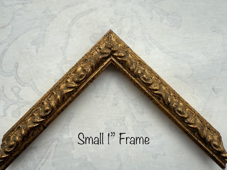 May include: A small, ornate gold-colored picture frame corner. The frame has a detailed, textured design. The text "Small 1" Frame" is written in black script. The frame is approximately 2.5 cm wide.