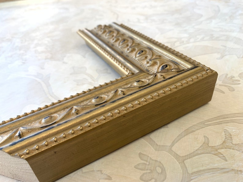 Pu&ograve; includere: Una cornice dorata con un designo ornato. La cornice &egrave; in legno e ha una finitura anticata.