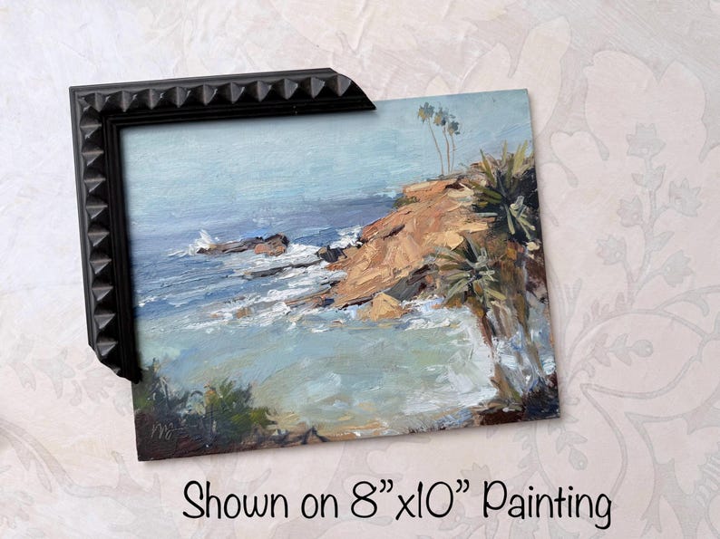 May include: An 8"x10" painting of a coastal scene with a black frame. The artwork depicts a rocky cliff, ocean waves, and a light blue sky. The painting has a textured, impressionistic style.