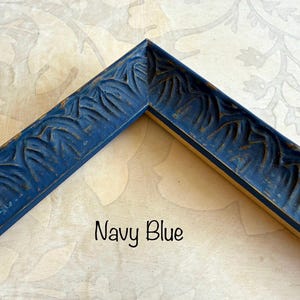 May include: Navy blue picture frame corner with carved leaf design. The frame has a distressed finish, with hints of gold peeking through the navy paint. The text "Navy Blue" is written in a script font.