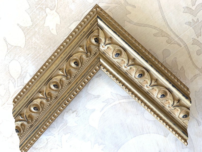 Pu&ograve; includere: Una cornice dorata con finitura anticata e dettagli decorativi. La cornice ha un bordo perlato e un design in rilievo.