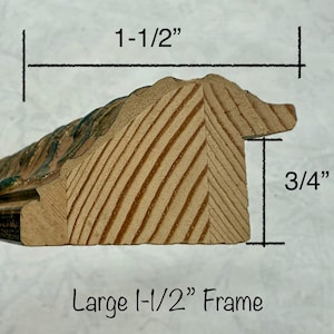 May include: Close-up of a wooden picture frame profile. The frame is 1-1/2 inches wide and 3/4 inches thick. The frame has a decorative edge with a painted finish. The text "Large 1-1/2" Frame" is visible.