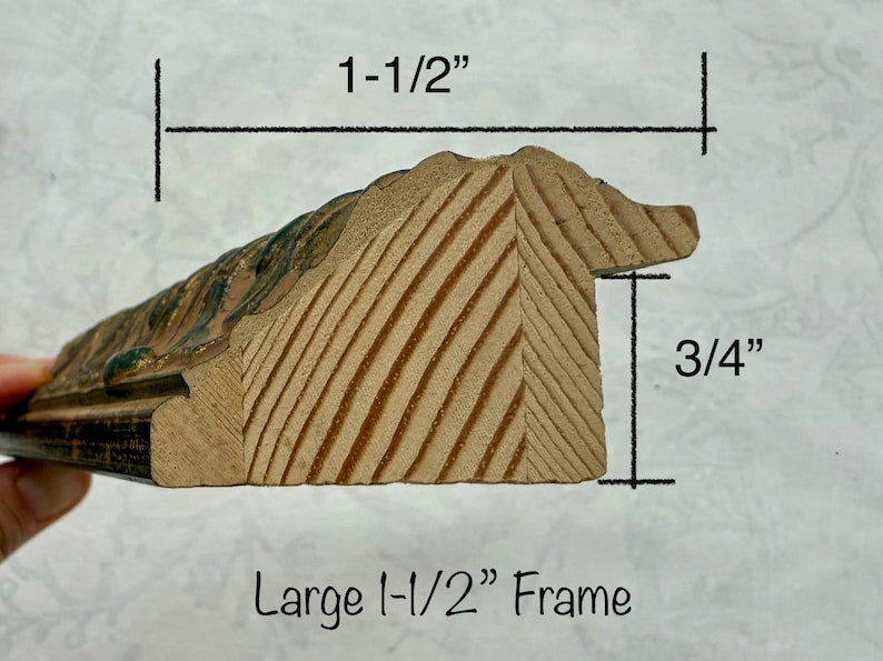 May include: Close-up of a wooden picture frame profile. The frame is 1-1/2 inches wide and 3/4 inches thick. The frame has a decorative edge with a painted finish. The text "Large 1-1/2" Frame" is visible.