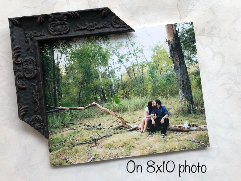 May include: A couple kissing whilst sitting on a fallen tree branch in a forest. The photo is printed on an 8x10 photo.