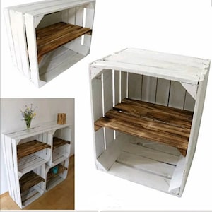 May include: White wooden crate shelf unit with two shelves. The shelves are made of natural wood. The crate is painted white.