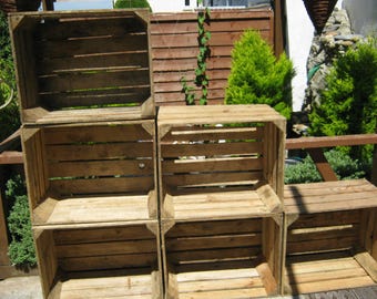 May include: A set of four wooden crates stacked on top of each other to create a shelf unit. The crates are made of natural wood and have a rustic look.