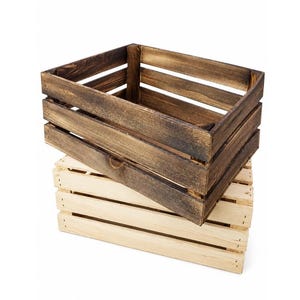 May include: A rectangular wooden crate with a dark brown stained finish is stacked on top of a second rectangular wooden crate featuring a natural light beige finish. Both crates are constructed with horizontal slats and open tops.