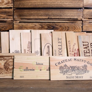 Può includere: Una collezione di casse di vino in legno con varie etichette e nomi, tra cui "Terrefort", "Casse", "Follet", "Chateau Saint-Go" e "L'Anv Saint Emilion Grand Cru".