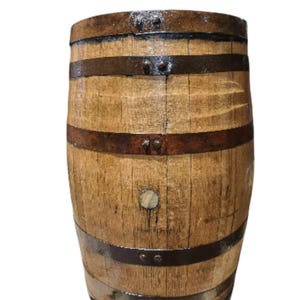 May include: A wooden barrel with dark metal bands. The barrel is made of light brown wood with visible grain and is slightly weathered. The metal bands are riveted to the wood, and the barrel has a slightly glossy finish.