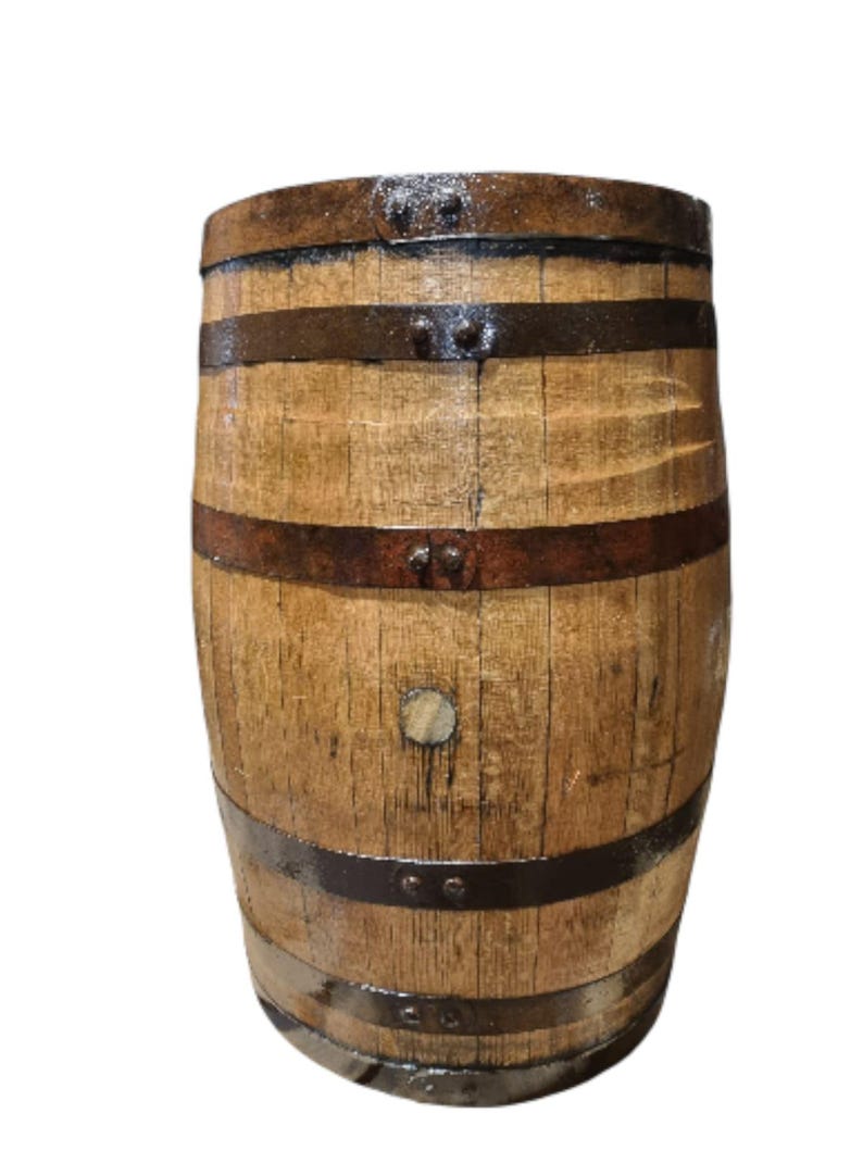 May include: A wooden barrel with dark metal bands. The barrel is made of light brown wood with visible grain and is slightly weathered. The metal bands are riveted to the wood, and the barrel has a slightly glossy finish.