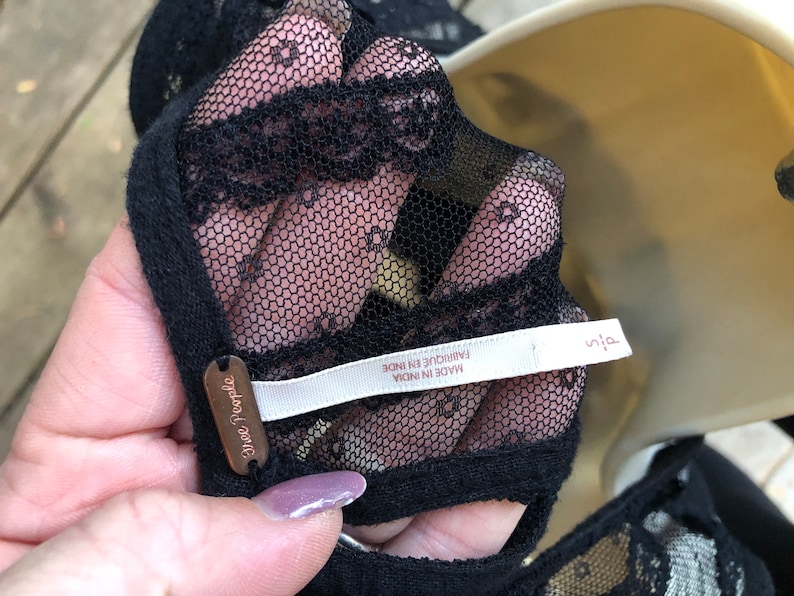 May include: Black lace top with a Free People tag and a white label that reads "Made in India, Fabrique en Inde".