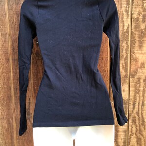 May include: A black long-sleeved shirt with a scoop neck.