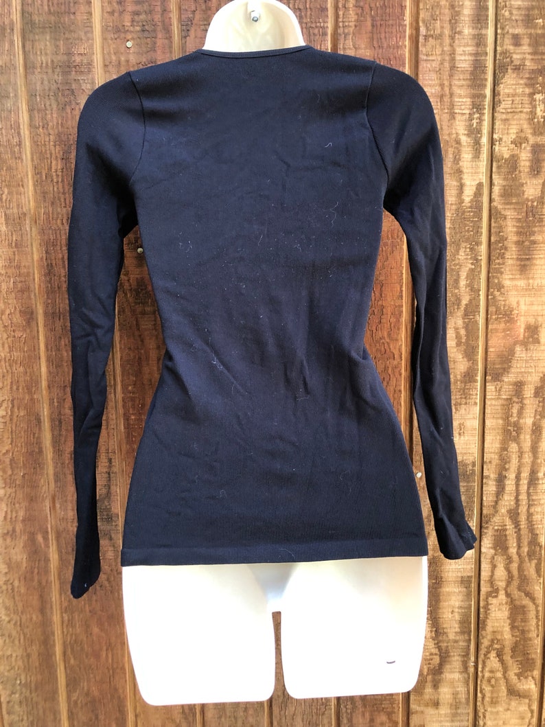 May include: A black long-sleeved shirt with a scoop neck.