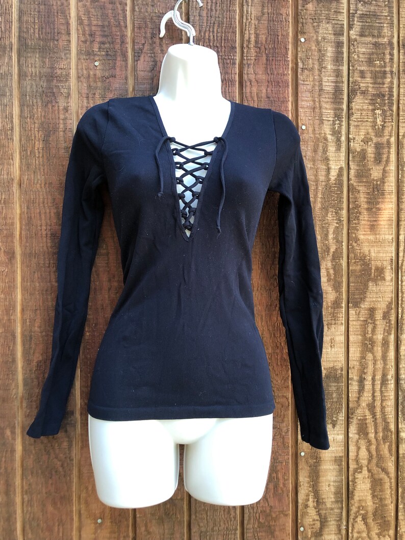 May include: Black long-sleeved shirt with a lace-up V-neck.