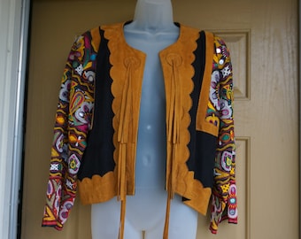May include: A brown suede jacket with colorful embroidery and fringe detailing. The jacket has a black lining and a scalloped edge.