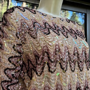 May include: A handmade, wooden cutting board with a natural finish. The rectangular board features a juice groove and a handle. The wood grain is visible, showcasing the natural beauty of the material. Dimensions are approximately 16 inches long and 10 inches wide.