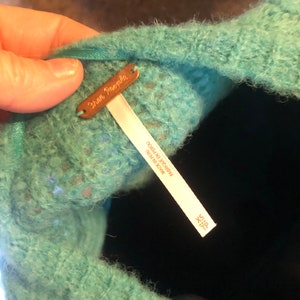 May include: A teal blue fuzzy sweater with a Free People tag and a size tag that says "Size X-S" and "Made in Peru".