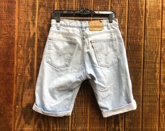 May include: Light blue denim shorts with a cuffed hem. The shorts have a brown leather patch with the Levi's logo on the back.