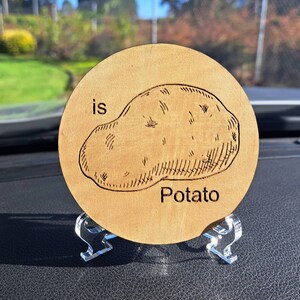 May include: A wooden coaster with a laser-engraved image of a potato and the text "is Potato".