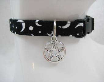 May include: Black choker collar with a white crescent moon and dot pattern. A silver pentagram charm hangs from the center. The collar has a black plastic buckle.