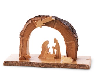 May include: A wooden nativity scene with a star above the manger. The figures are carved from wood and the manger is made from a piece of tree bark.