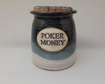 May include: A blue and white ceramic jar with a cork lid. The jar has the words "Poker Money" written on it.