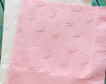 May include: Two paper napkins, one white and one pink, with embossed strawberry patterns. The pink napkin has a textured border. The strawberries are evenly spaced across the surface of the napkins, creating a charming and decorative design.