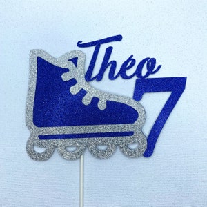 May include: Blue and silver glitter roller skate cake topper with the name Theo and the number 7.